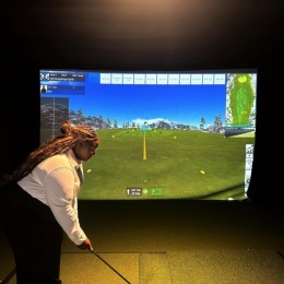 woman playing a golf simulator